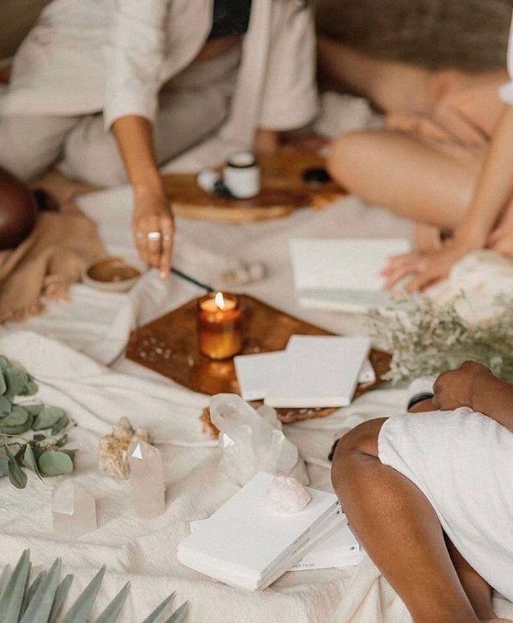 Women gathered around notebooks and candlelight